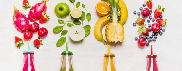 fruit and vegetable smoothies in glass bottles with straws