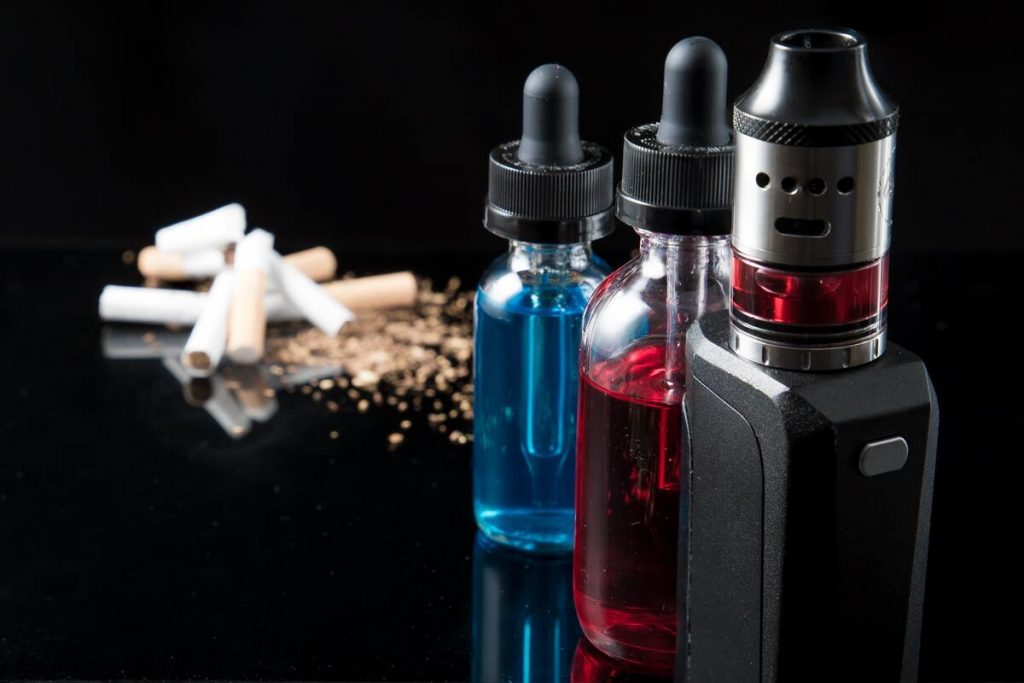 e liquid bottles with vape device and cigarettes