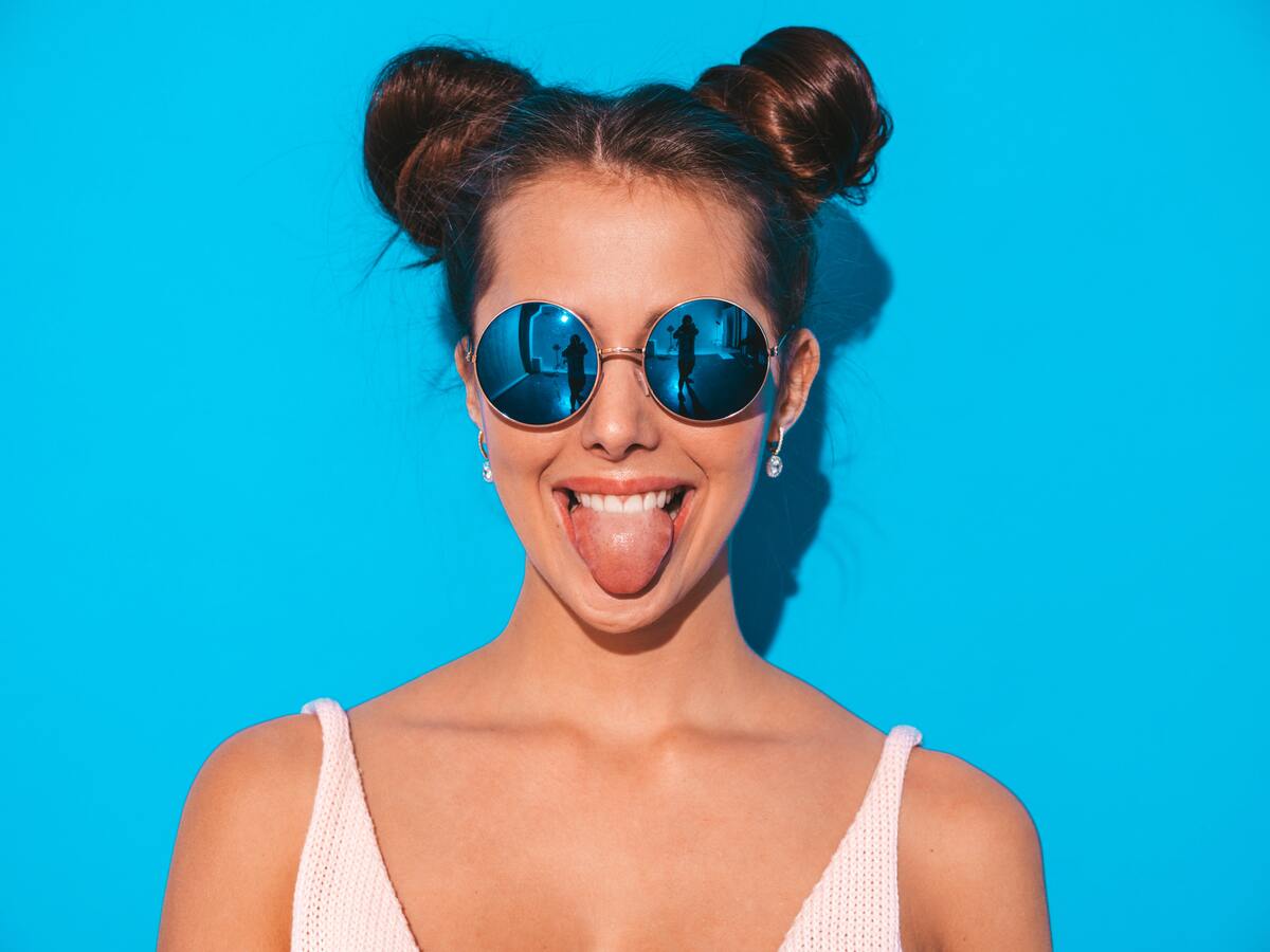 woman in sunglasses shows her tongue